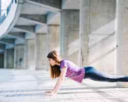 Free photo sportive girl working out doing push ups