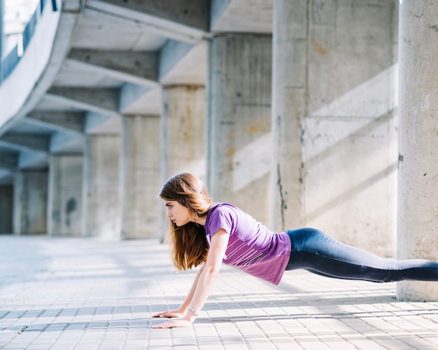 Sportive girl working out doing push ups 