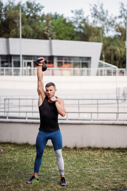 Kettlebell으로 훈련하는 낚시를 좋아하는 사람. 체격이 좋은 잘 생긴 남자. 힘과 동기.