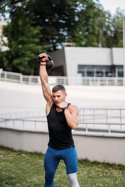 Free photo sportive guy training with kettlebell