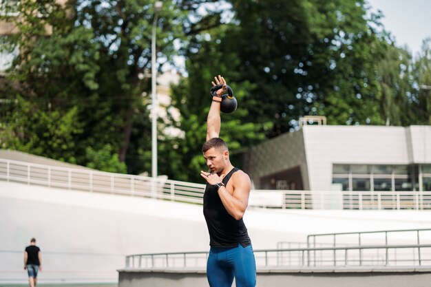 ケトルベルでトレーニングするスポーティーな男。