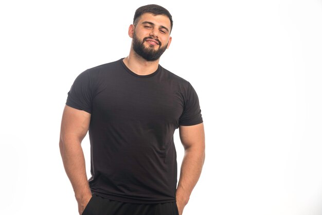 Sportive man in black shirt posing. 