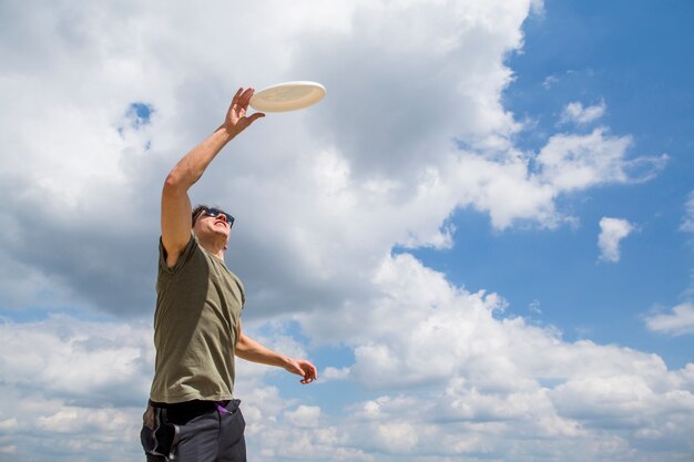 Sportive man catching plastic disc