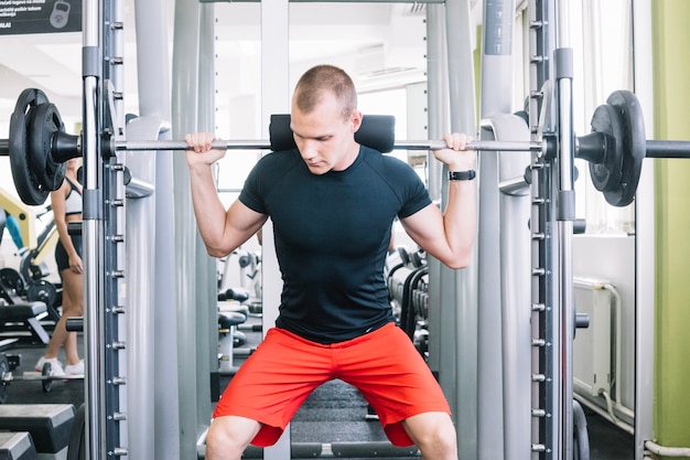 Sportive man lifting bar 