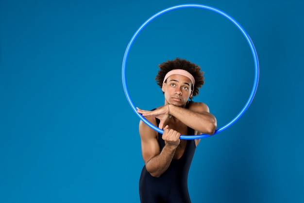 Sportive man posing with hoop