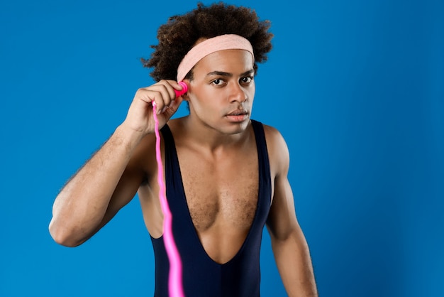 Sportive man posing with skipping rope