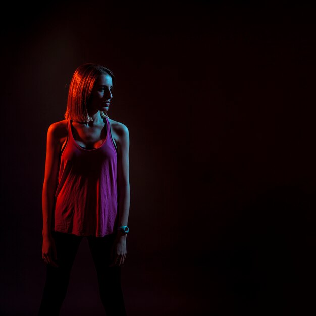 Sportive woman in dark neon lights