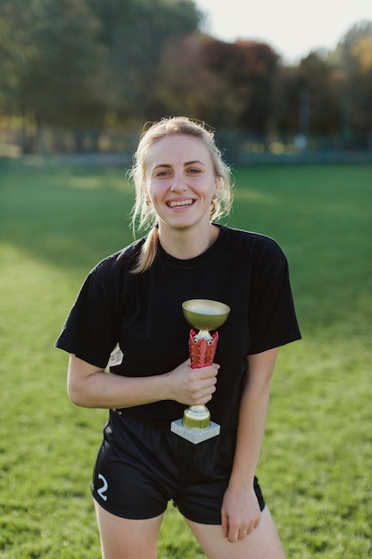 Foto gratuita donna allegra che tiene un trofeo