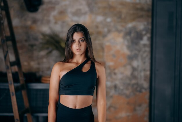 Sportive woman in sportswear posing at the camera sport and gym concept