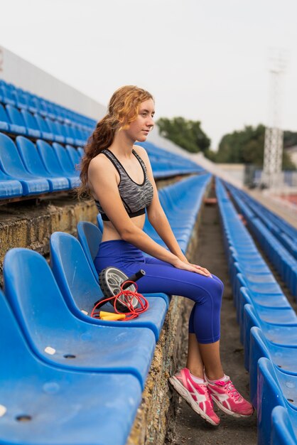 Sportive woman at stadium sitting