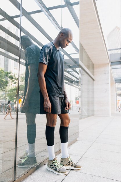 Sportive young athlete young man standing against mirror