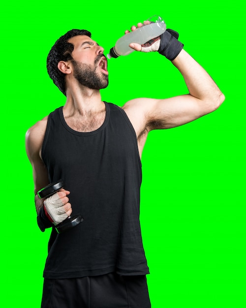Free photo sportman doing weightlifting drinking water soda