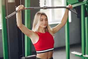 Бесплатное фото Спортивная блондинка в спортивной тренировке в тренажерном зале