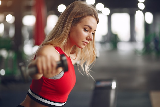 Sports blonde woman in a sportswear training in a gym