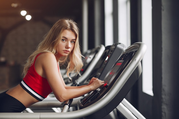 Sports blonde woman in a sportswear training in a gym