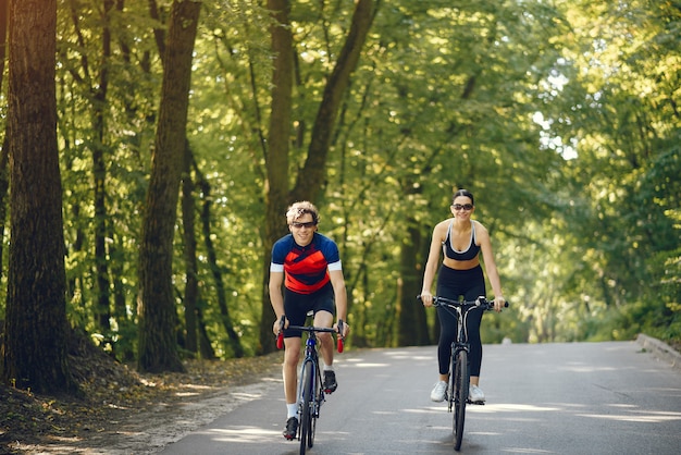 Free photo sports couple riding bikes in summer forest