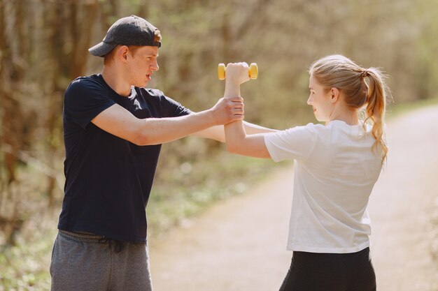 Sports couple training in a summer forest