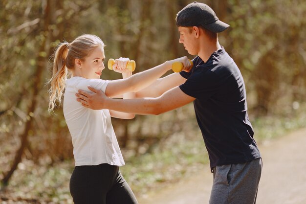 Sports couple training in a summer forest