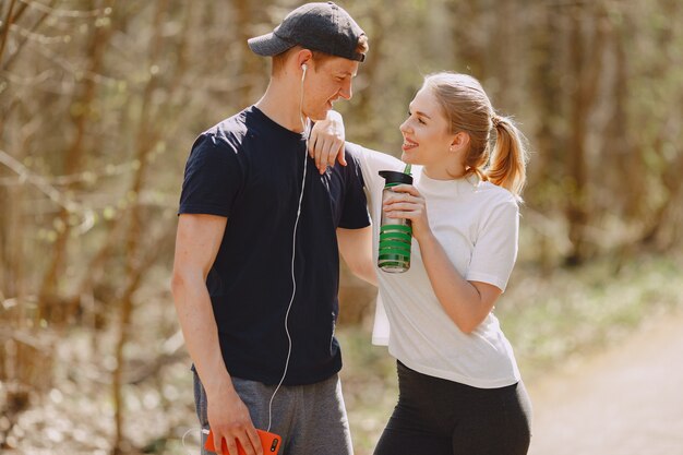 Sports couple training in a summer forest