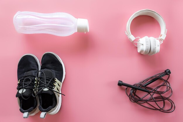 Sports equipment items on pink background flat lay