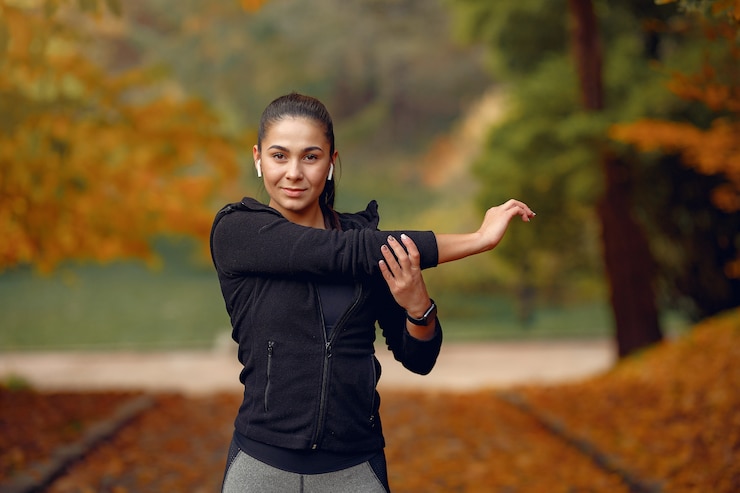 Free Photo sports girl in a black top training in a autumn park
