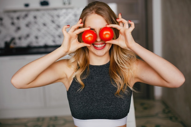 Free photo sports girl in a kitchen with vegetables