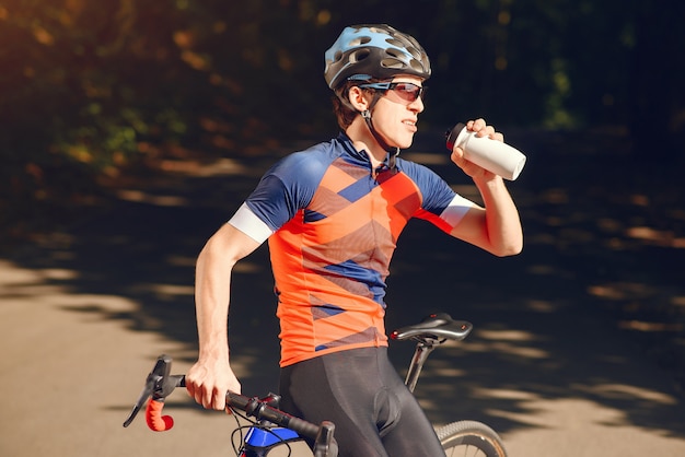 Sports man riding bike in summer forest