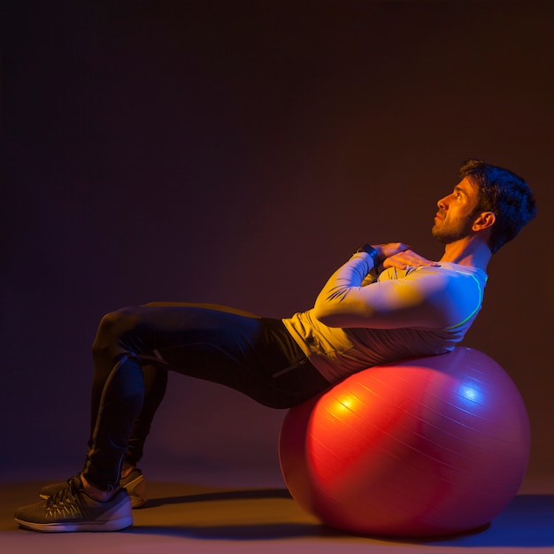 Free photo sportsman exercising on fitball