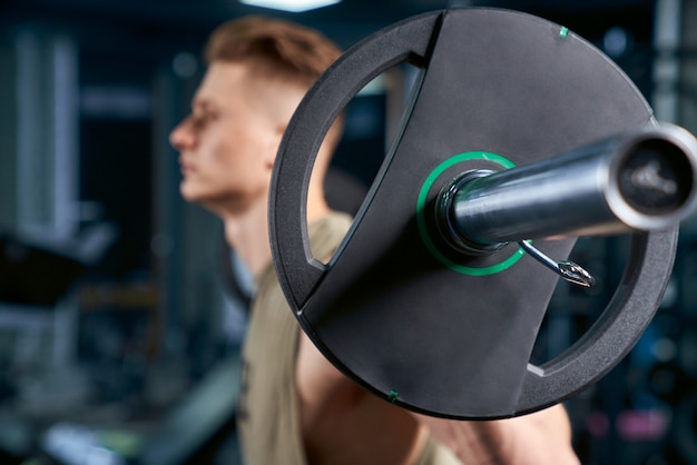 Free photo sportsman holding barbell on shoulders.