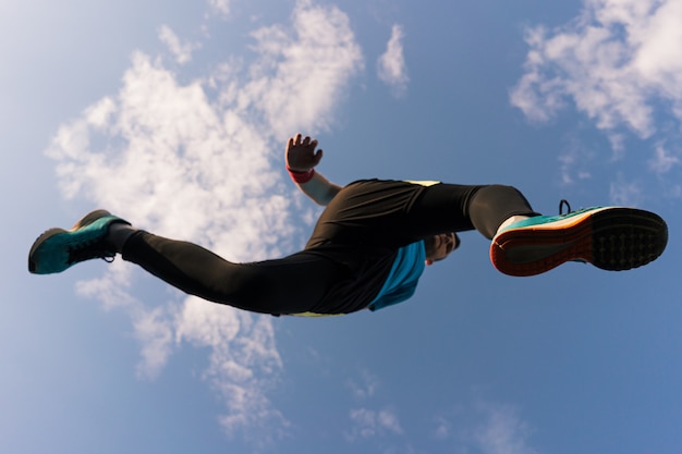 Бесплатное фото Спортсмен бежит и прыгает в небо