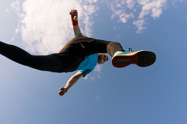 Спортсмен бежит и прыгает в небо