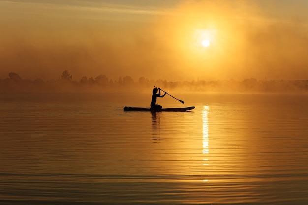 Sportsman in silhouette roaming on board during sunrise