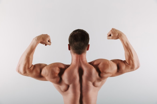 Sportsman standing showing biceps.