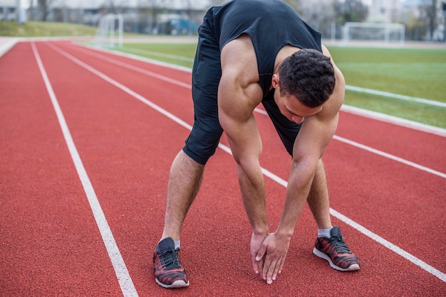 Sportsman stretching hands at the stadium