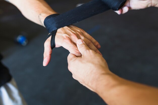 Sportsmen taping hand with band