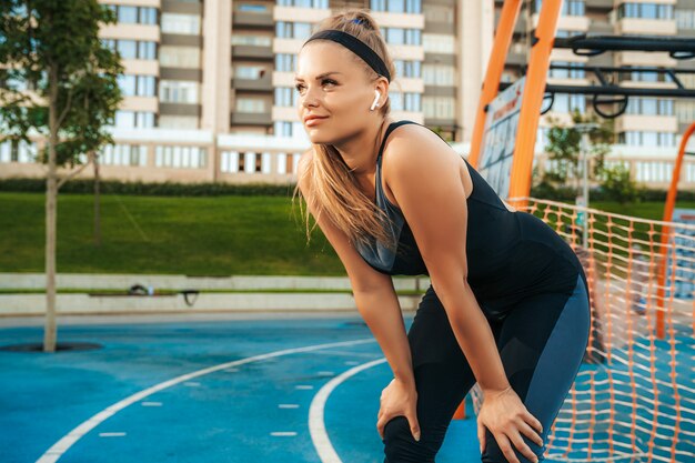 Sportswoman listening to music in earphones