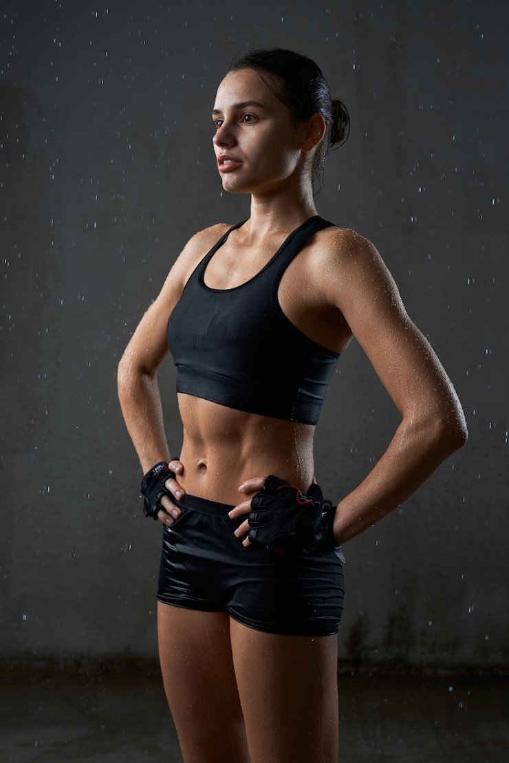 Free Photo sportswoman posing in sportswear isolated on gray