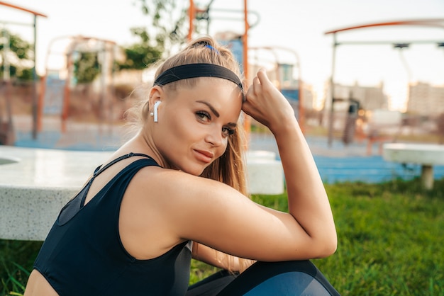 Sportswoman resting and listening to music