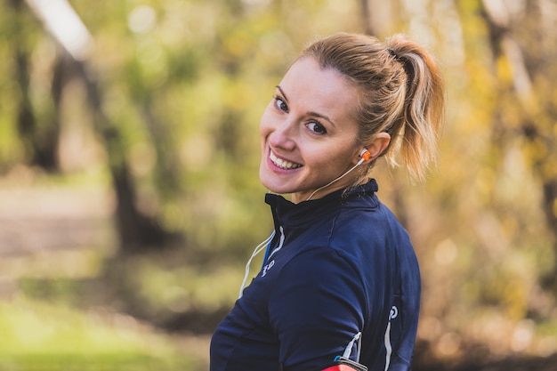 Sportswoman smiling and listening to music