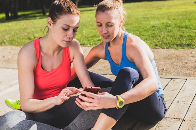 Sportswomen watching photos on mobile