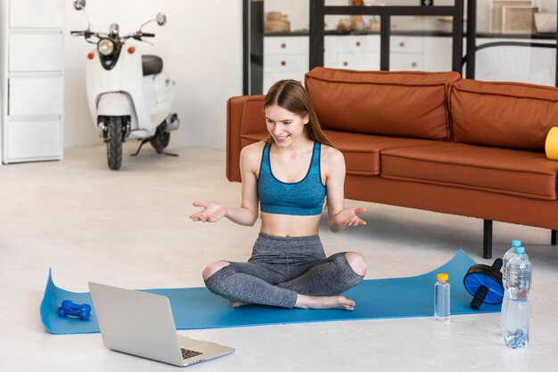 Free photo sporty blogger sitting in front of laptop