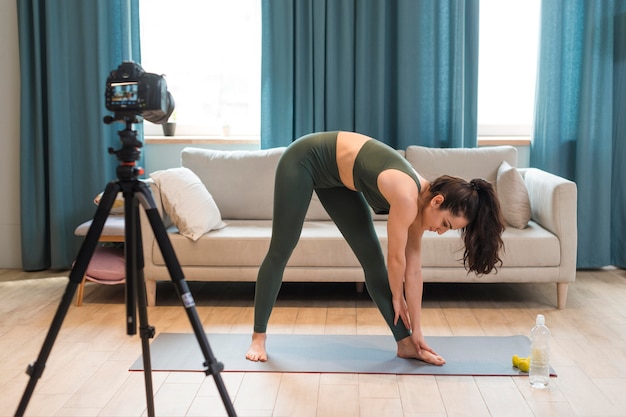 Free photo sporty blogger stretching down in front of camera