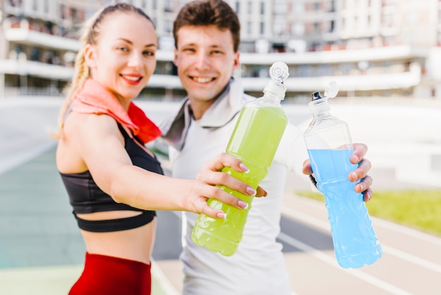 Sporty couple showing energy drinks