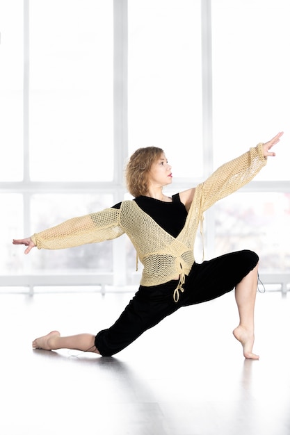 Dancing femminile sportiva, equilibrando in posa lunga in classe