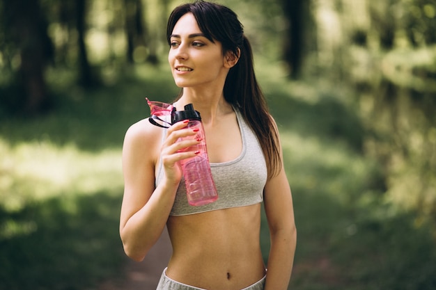 公園のスポーティな女の子の飲料水