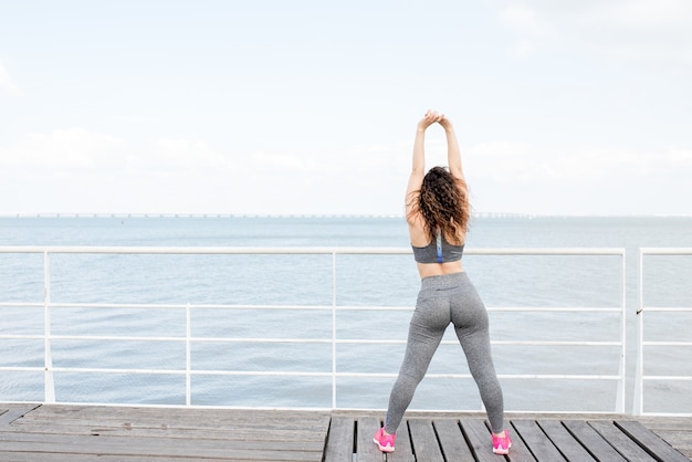 Sporty Girl Exercising on Quay by River