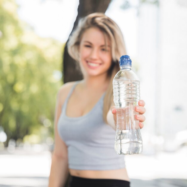 Foto gratuita ragazza sportiva che tiene bottiglia d'acqua