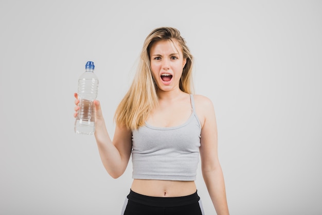 Foto gratuita ragazza sportiva che tiene bottiglia d'acqua