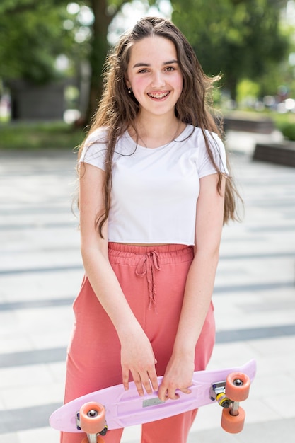 Sporty girl holding her skateboard