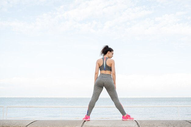 Sporty Girl Posing on Parapet by River